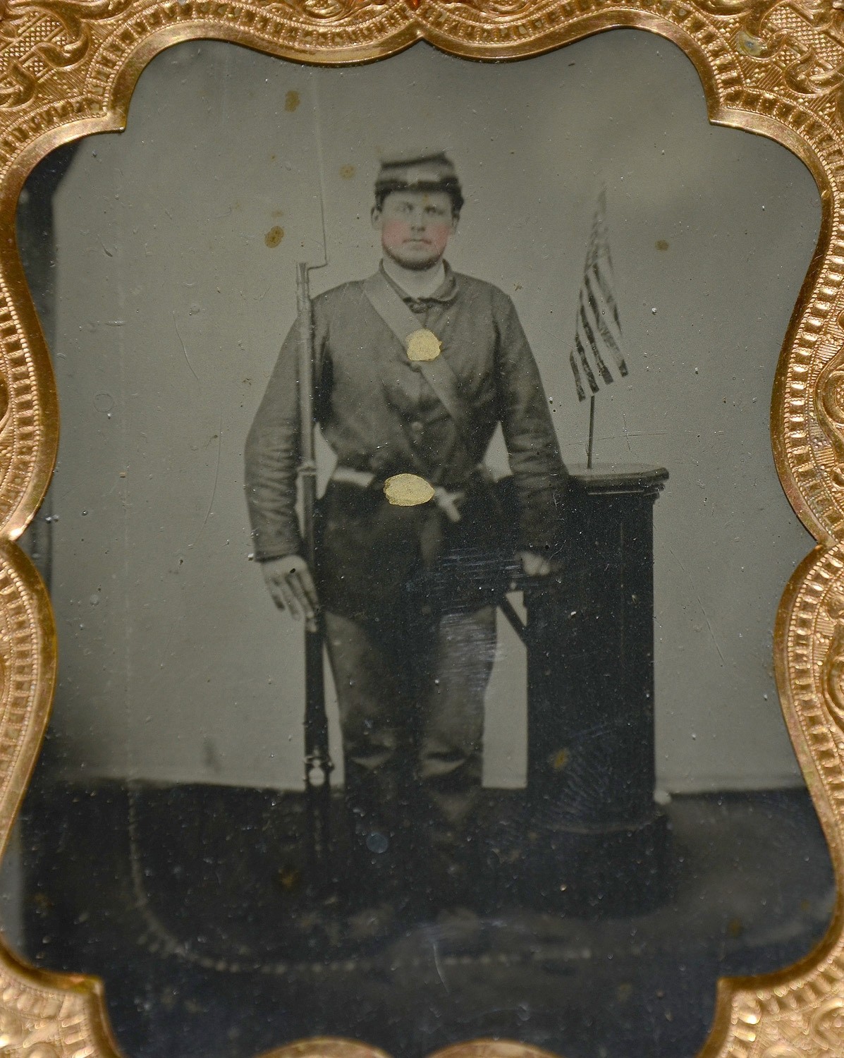 QUARTERPLATE TINTYPE OF ARMED UNION SOLDIER WITH US FLAG