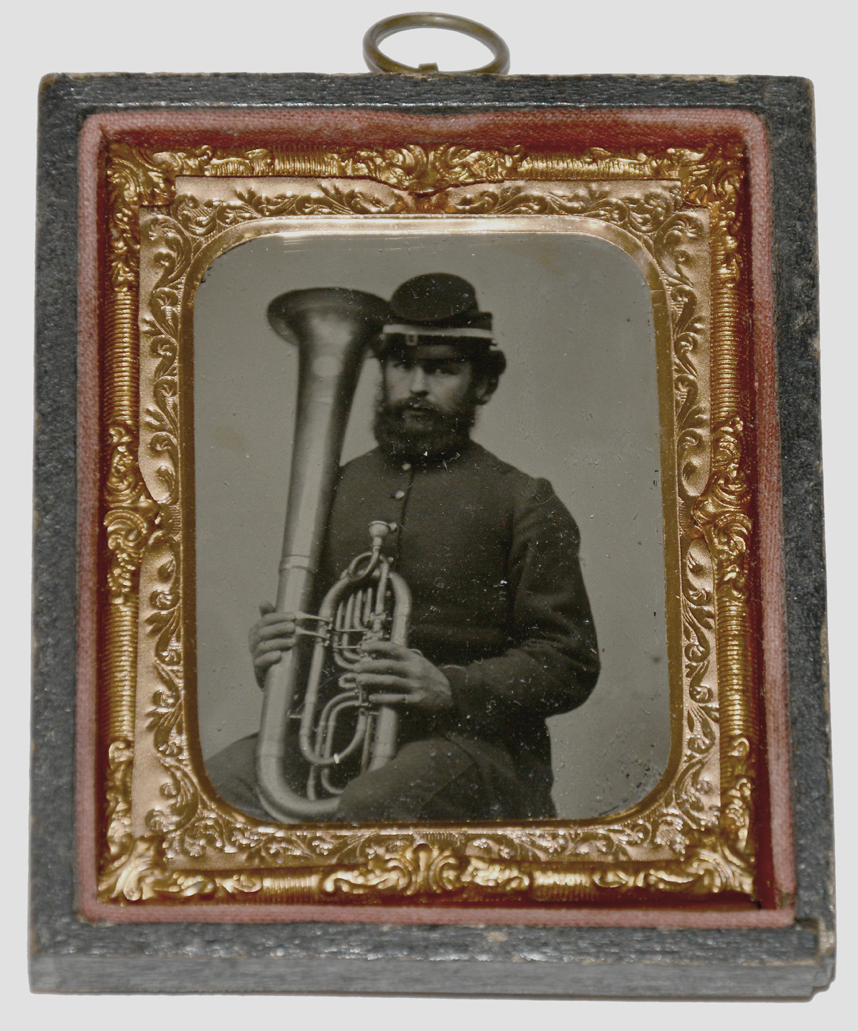 WONDERFUL NINTH-PLATE RUBY AMBROTYPE SEATED VIEW OF A SOLDIER WTH A SAXHORN