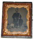 SIXTH PLATE TINTYPE OF MAN HOLDING A RIFLE WITH SLEEPING DOG