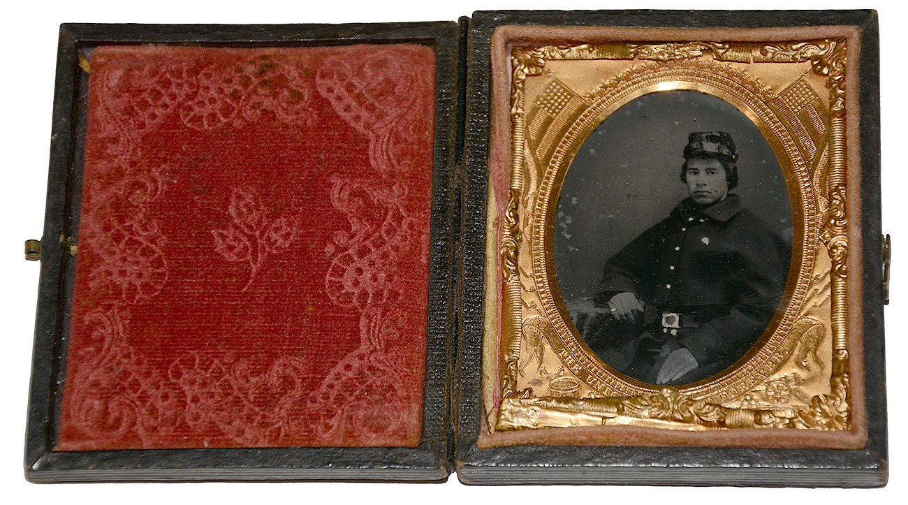 NINTH-PLATE TINTYPE OF A YOUNG UNION SOLDIER WITH OVERCOAT AND RAIN COVER FOR CAP