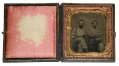 SIXTH-PLATE TINTYPE OF TWO SEATED FRIENDS - ONE ARMED WITH A HOLSTER