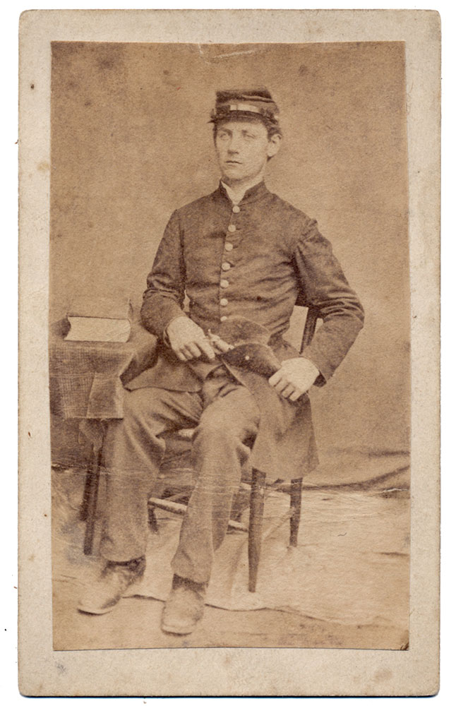 FULL SEATED VIEW OF A UNION SOLDIER ARMED WITH A REVOLVER