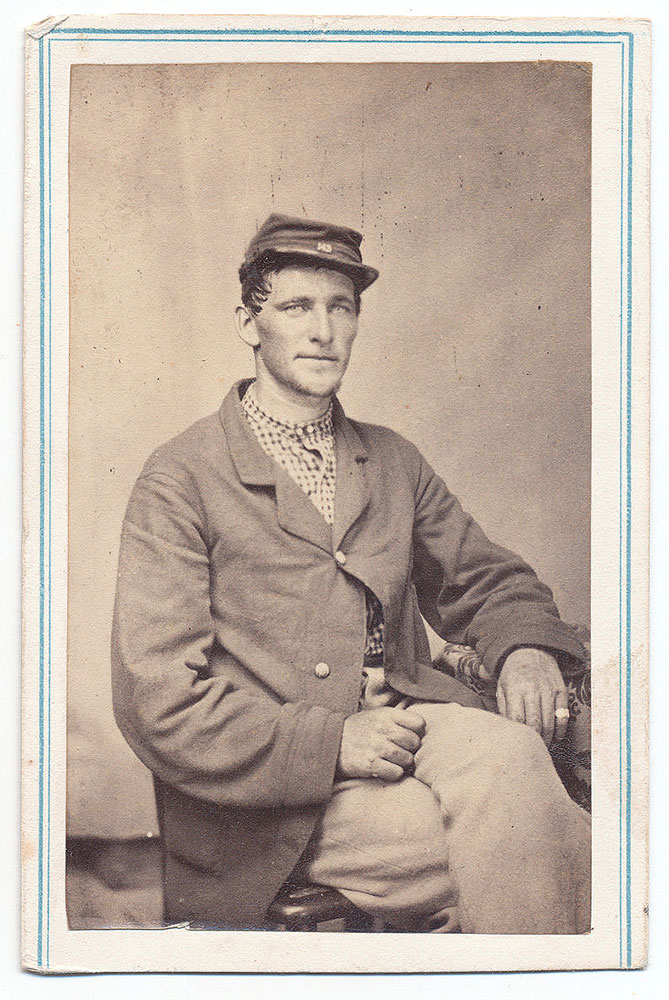 INK ID THREE-QUARTER SEATED VIEW OF 143RD NEW YORK SOLDIER DISPLAYING HIS REGIMENTAL NUMBER ON THE CHINSTRAP OF HIS CAP – JAMES A. EICHENBURGH