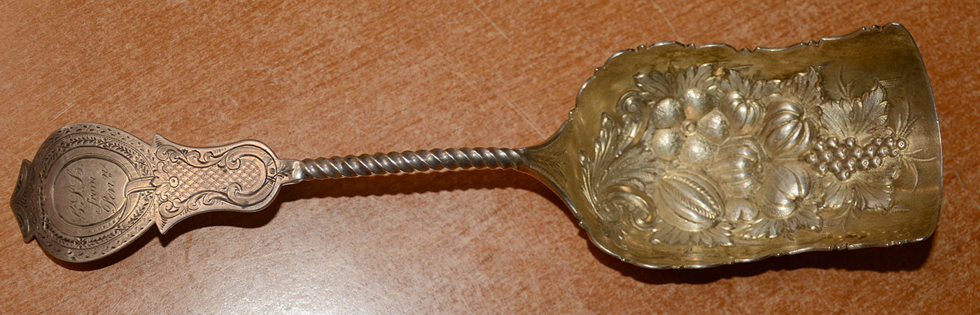 SILVER SHOVEL SPOON WITH FRUIT AND GOURD MOTIF BY W.S. BROWN & CO.