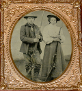 1/6 PLATE TINTYPE OF MAN AND WOMAN POSING WITH TRAPDOOR RIFLES WITH BAYONETS