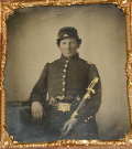 1/6 PLATE TINTYPE IN PATRIOTIC CASE OF UNION OFFICER WITH PAIR OF PISTOLS AND SWORD
